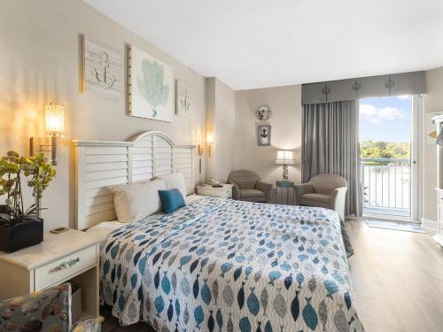 1 dormitorio con 1 cama grande y balcón en Harbourgate Marina #312, en Myrtle Beach