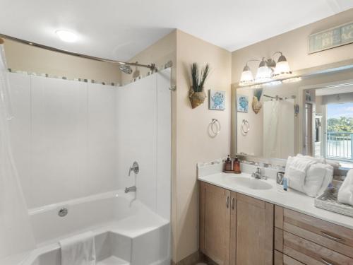 een badkamer met een bad, een wastafel en een spiegel bij Harbourgate Marina #312 in Myrtle Beach