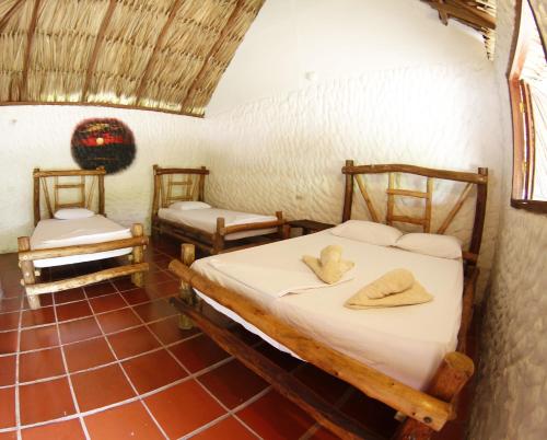 a room with two beds with towels on them at Praba Hostel in Palomino