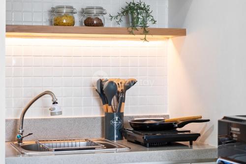 a kitchen counter with a sink and a stove at Eunoia by Kozystay - Serpong in Tangerang