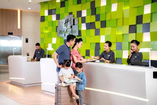 un grupo de personas parados alrededor de un mostrador en una tienda en Holiday Inn & Suites Saigon Airport, an IHG Hotel, en Ho Chi Minh