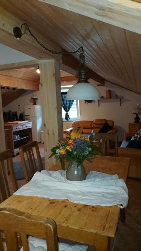 a wooden table with a vase of flowers on it at Ferienwohnung Trina in Bendorf