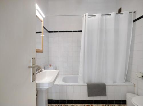 y baño con bañera, lavamanos y cortina de ducha. en Casa Julia, en La Laguna