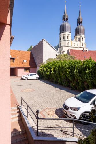 two cars parked in a parking lot in front of a church at HOTEL Garni PATRIOT in Trnava