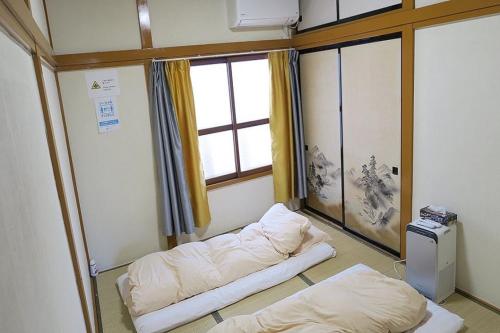 a hospital room with two beds and a window at FUJI新倉山 in Azagawa