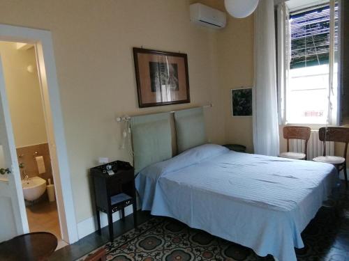 a bedroom with a bed and a bathroom with a window at Villa Manasse in Aci Castello