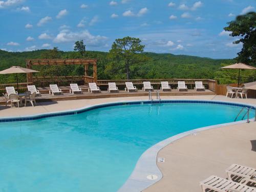 a large swimming pool with chairs and umbrellas at Mountain Top Inn and Resort in Warm Springs