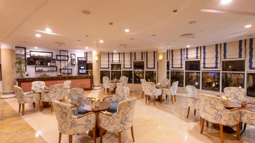 a dining room with tables and chairs and windows at Naama Bay Hotel & Resort in Sharm El Sheikh