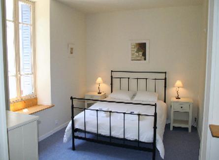a bedroom with a bed with two night stands and a window at Hotel Bermond in Saint-Julien-en-Beauchêne