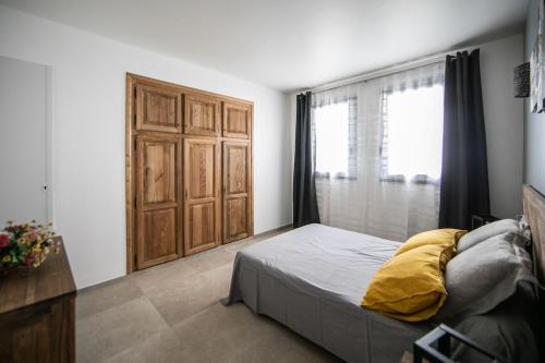 een slaapkamer met een bed en een houten deur bij SARTENE t3 CALME ENSOLEILLÉ PARKING PRIVÉ in Sartène
