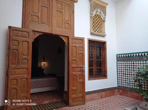 a room with a wooden door and a bed at Riad Dar Badiaa in Sale