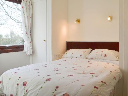 a bedroom with a bed with a floral comforter and a window at Chalet 3 - Uk30304 in Tore