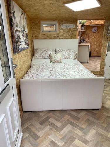 a large white bed in the middle of a room at Pen-Y-Bryn Annex in Brynmenin