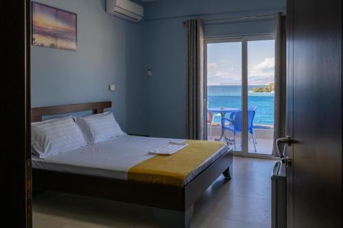 um quarto com uma cama e vista para o oceano em Hotel De Luna em Ksamil