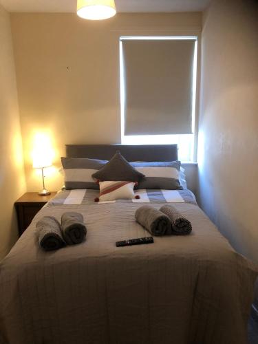 - une chambre avec un lit, des serviettes et une fenêtre dans l'établissement Henry’s Flat Cardiff, à Cardiff