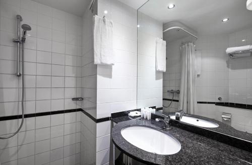 a bathroom with two sinks and a shower at Gentofte Hotel in Gentofte