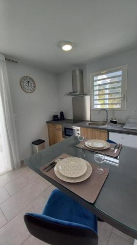 a kitchen with a table with two plates on it at Appartement au cœur du village d'HellBourg in Salazie