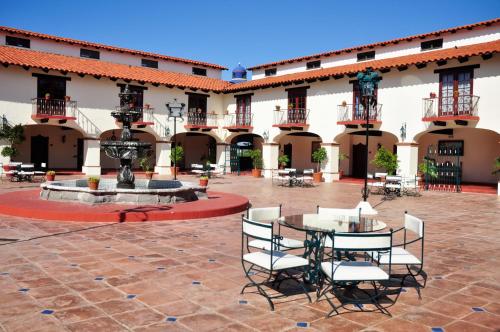 een binnenplaats met een tafel en stoelen en een fontein bij Hacienda Bajamar in Sonorabampo