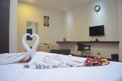 two white swans are sitting on top of a bed at The Himalaya Park in Bhilai