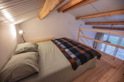 1 dormitorio con 1 cama en una habitación con suelo de madera en 't Winkeltje - Vakantiehuisje op boerderij Huize Blokland, en Hem