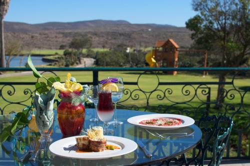 a table with two plates of food and wine glasses at Hacienda Bajamar in Sonorabampo