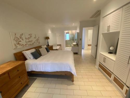 a bedroom with a large white bed and a bathroom at Maison La Plage by Simply-Seychelles in Eden Island