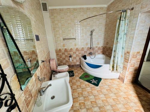 a bathroom with a tub and a toilet and a sink at Hotel-RIVERSIDE in Tashkent