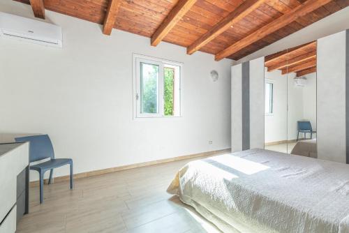 a bedroom with a bed and a desk and a window at Villa Lorenzo in Avola