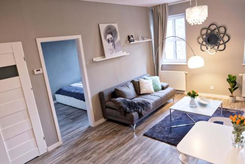 a living room with a couch and a mirror at BanApart Apartments in Zgorzelec