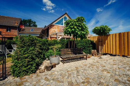 a house with a fence and a tree in a yard at Altes Gewölbe mit Sauna und Whirlpool im Außenbereich in Elsterheide
