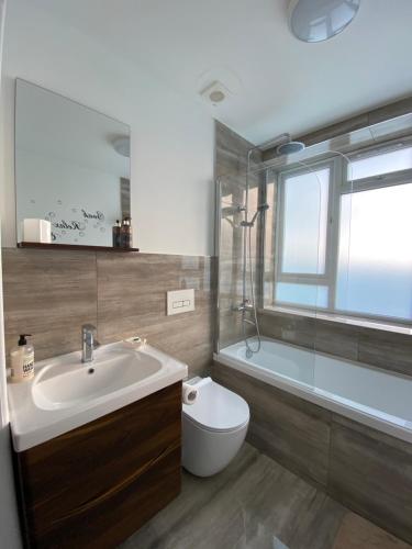 W łazience znajduje się umywalka, toaleta i prysznic. w obiekcie Rooftops Apartment w mieście Bletchley