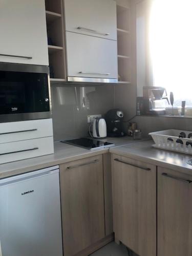 a kitchen with white cabinets and a counter top at MyHome2 in Subotica