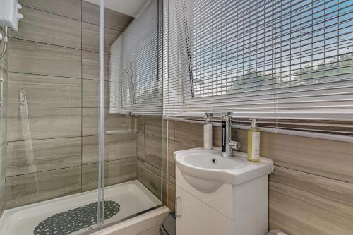 a bathroom with a toilet and a sink and a shower at Suites by Rehoboth - Overcomers- Deptford in London