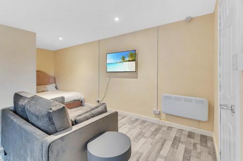 a living room with a couch and a bed at Suites by Rehoboth - Overcomers- Deptford in London