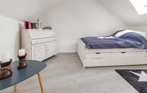 a bedroom with a white bed and a table at Altes Gewölbe mit Sauna und Whirlpool im Außenbereich in Elsterheide