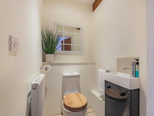a white bathroom with a toilet and a sink at The Barn At Whitefields in Walcot