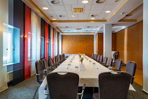 a conference room with a long table and chairs at Hotel Mercator Itzehoe-Klosterforst in Itzehoe