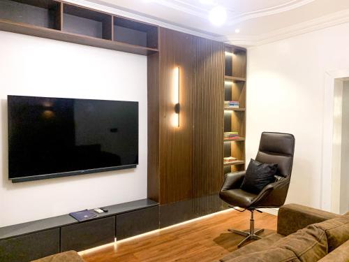 a living room with a couch and a television on a wall at Whytescape Serviced Apartments in Abuja