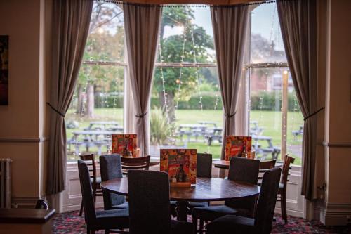 comedor con mesa, sillas y ventana en Highfield Hotel en Middlesbrough