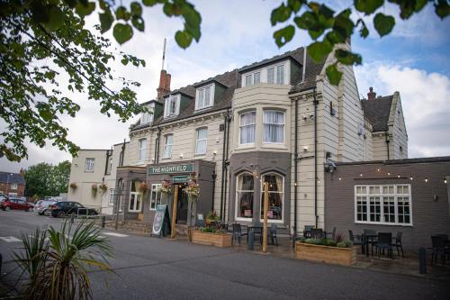 a building on the corner of a street at Highfield Hotel By Greene King Inn in Middlesbrough