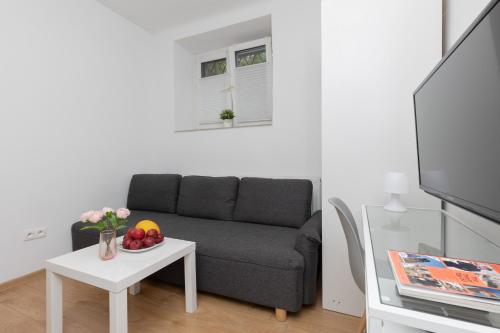 uma sala de estar com um sofá e uma mesa em Micro Apartment near Fort Mokotów em Varsóvia