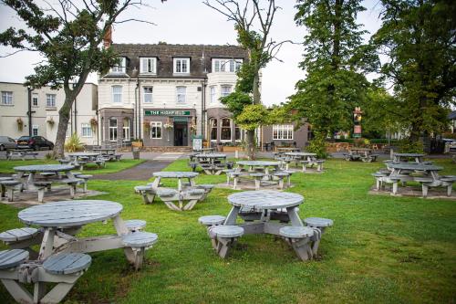 a group of picnic tables in front of a building at Highfield Hotel By Greene King Inn in Middlesbrough