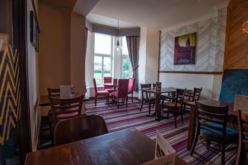 a dining room with tables and chairs and a window at Highfield Hotel By Greene King Inn in Middlesbrough
