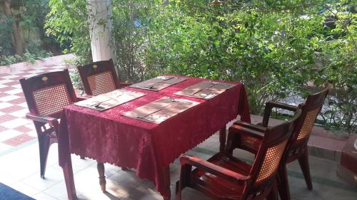 コーチにあるSithara Homestay Fort Cochinのテーブル(椅子4脚、赤いテーブルクロス)