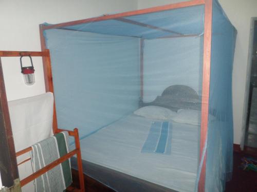 1 cama con dosel azul en una habitación en Grand Villa, en Mirissa