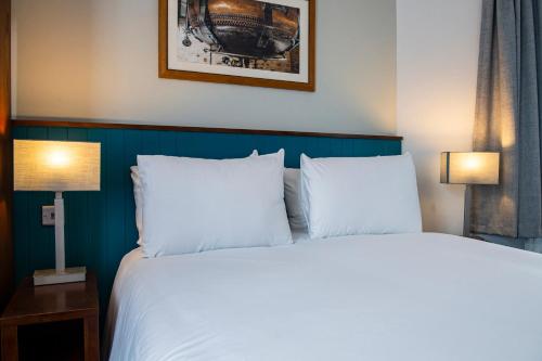 a bedroom with a bed with two white pillows at Highfield Hotel By Greene King Inn in Middlesbrough