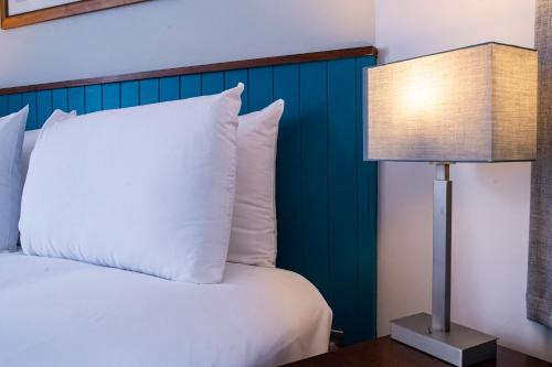 a bed with a white pillow next to a lamp at Highfield Hotel By Greene King Inn in Middlesbrough