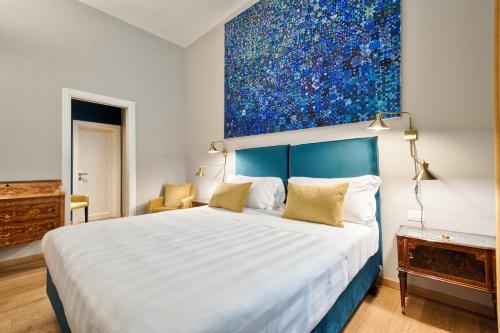 a bedroom with a large bed with a painting on the wall at Palazzo Del Carretto-Art Apartments and Guesthouse in Turin
