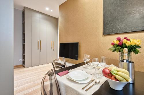 a dining room with a table with a bowl of fruit at Palazzo Del Carretto-Art Apartments and Guesthouse in Turin