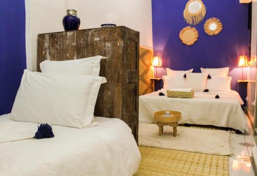 a bedroom with two beds with white pillows at Riad Amra in Marrakesh